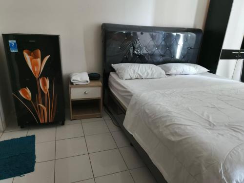 ein Schlafzimmer mit einem Bett und einem Nachttisch neben einem Bett sidx sidx sidx in der Unterkunft Dahoma lantai 6 in Tjikuda Tiga