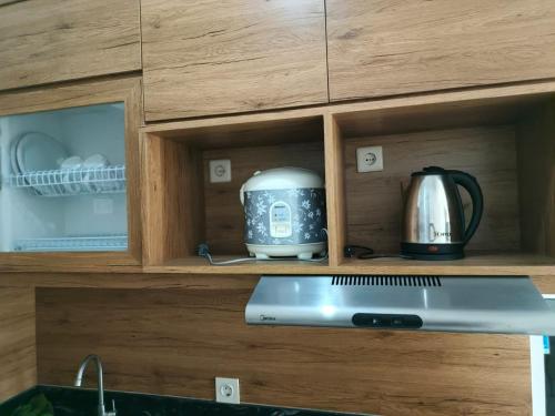 ein Toaster und eine Teekanne in einem Schrank in der Unterkunft Dahoma lantai 6 in Tjikuda Tiga