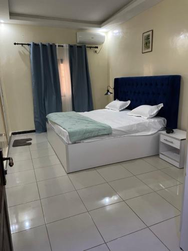 a bedroom with a bed with a blue headboard at Se loger au Senegal in Darou Rhamane
