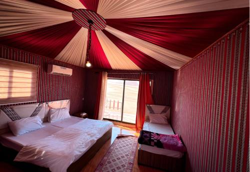 a bedroom with a bed in a red tent at Rum rose luxury camp in Wadi Rum