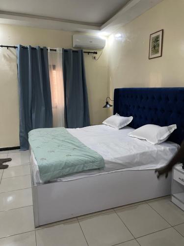 a bed with a blue headboard in a bedroom at Se loger au Senegal in Darou Rhamane