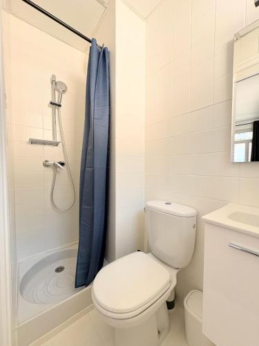 une salle de bain blanche avec toilettes et douche dans l'établissement Lourdes Backpackers, à Lourdes