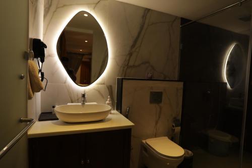 a bathroom with a sink and a toilet and a mirror at Bangalore Hideaway 1BHK Spanish villa Casa Rio in Denkanikota