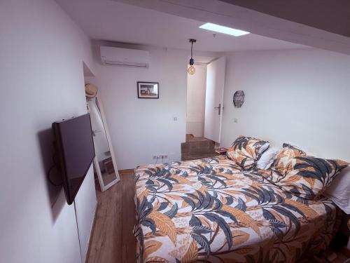 une chambre avec un lit et une télévision à écran plat dans l'établissement Charme, Pierres, Appartement Vieil Antibes, à Antibes