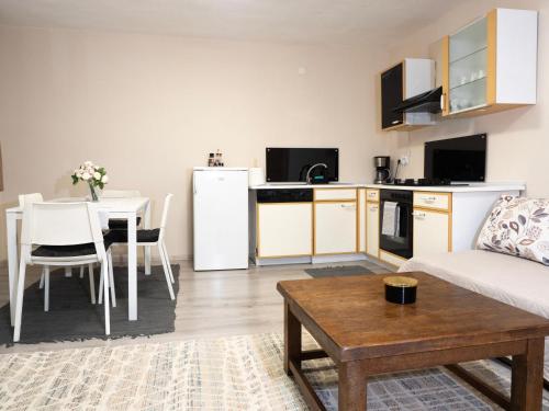 スタツィウネア・クリマテリカ・スンバタにあるCăsuța cu Braziのリビングルーム(ソファ付)、キッチン(テーブル付)