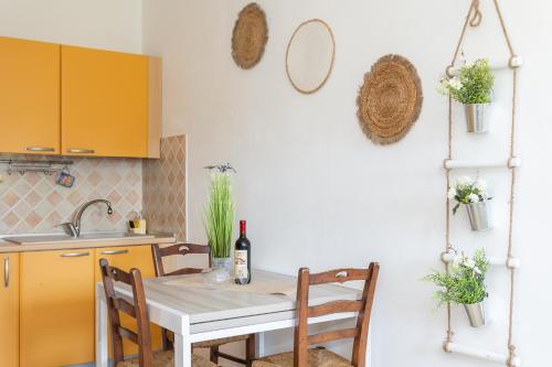 a kitchen with a table with a bottle of wine at Long Green House in Sorso