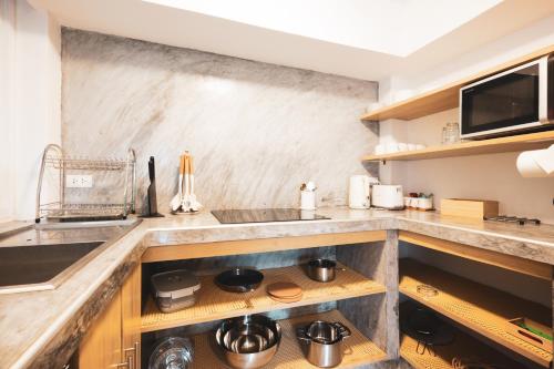 a kitchen with a sink and a counter with pots and pans at Top Notch View Villa in Koh Tao