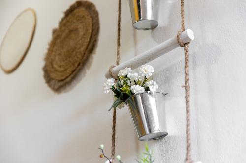 a vase with flowers in it hanging on a wall at Long Green House in Sorso