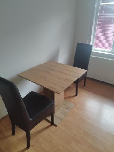 a wooden table and two chairs in a room at Salvatori in Garić