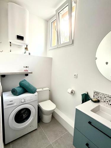 une salle de bain avec une machine à laver et un lavabo dans l'établissement Plain-pied lumineux & terrasse, à Mireval