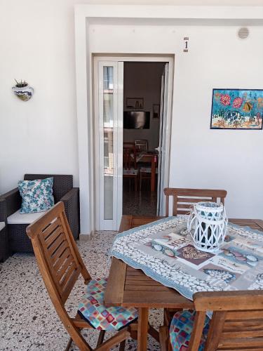 a dining table and chairs in a living room at La veranda dei remi azzurri in Lido Conchiglie