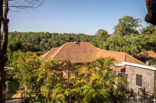 a house with a tiled roof and palm trees at Pax Manor Muthaiga in Nairobi
