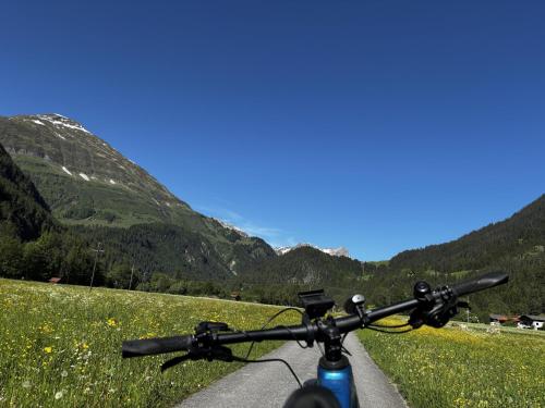 a bike parked on a road with mountains in the background at Haus Carolus in Elbigenalp
