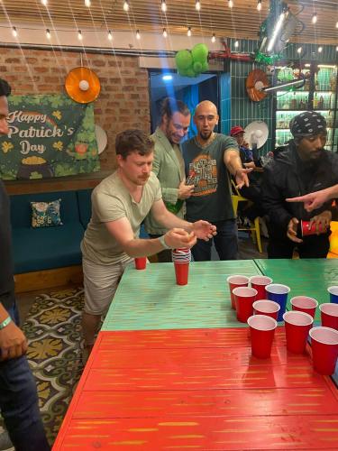 a group of people standing around a table with red cups at Rango Hostel Boutique in Medellín