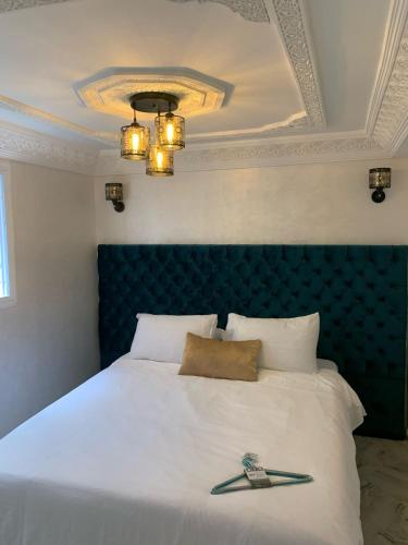 a bedroom with a bed with a blue headboard at chez saad in Fès