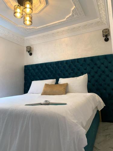 a bedroom with a large bed with a blue headboard at chez saad in Fès