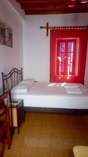 a bedroom with two beds and a red window at Studio Eleni in Mýkonos City