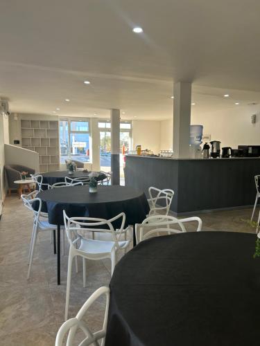 a restaurant with tables and chairs and a counter at Hotel Vista Kau in Añelo