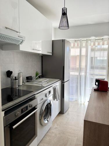 Il comprend une cuisine équipée d'une cuisinière et d'un lave-linge/sèche-linge. dans l'établissement Appartement proche de la plage et du centre ville, à Sainte-Maxime