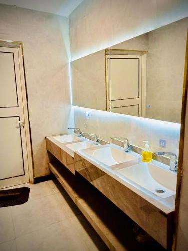 a bathroom with two sinks and a large mirror at Hotel Chatha Manoura- in Medina