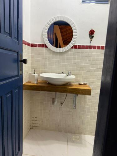 a bathroom with a sink and a mirror at VILA ACONCHEGO AZUL- casa 1 in Aracê