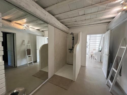 une grande pièce avec des murs et des plafonds blancs et un couloir dans l'établissement Maison de Charme Uzes piscine 6 à 7 Personnes en pleine nature, à Saint-Siffret