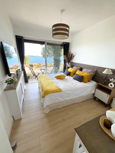 une chambre avec un grand lit avec des oreillers jaunes dans l'établissement Expérience unique face à la mer et Porquerolles, à Carqueiranne