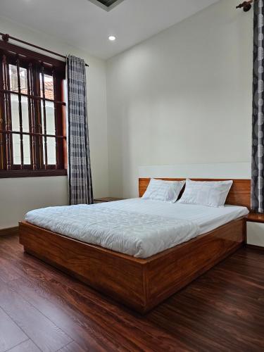 a bedroom with a large wooden bed in a room at BIỆT THỰ NGHĨ DƯỠNG CAO CẤP THUỲ VÂN BÃI SAU VŨNG TÀU-Mt VƯƠNG VILLA in Vung Tau