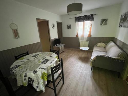 un salon avec une table et un canapé dans l'établissement Gites La Garrigue, à Tamniès
