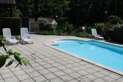 - une piscine avec deux chaises longues et une paire dans l'établissement Gites La Garrigue, à Tamniès