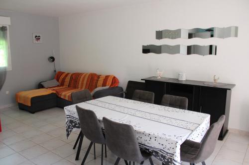 un salon avec une table, des chaises et un canapé dans l'établissement Gites La Garrigue, à Tamniès