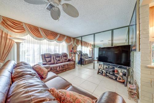 a living room with a leather couch and a flat screen tv at 4 Mi to Hard Rock Stadium Miramar Home with BBQ! in Miramar