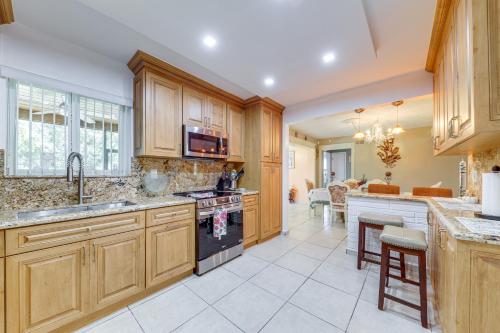 a kitchen with wooden cabinets and a stove top oven at 4 Mi to Hard Rock Stadium Miramar Home with BBQ! in Miramar