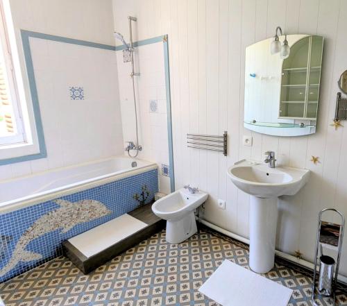 a bathroom with a sink and a tub and a toilet at Château de Camperos in Barsac