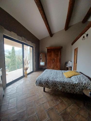 une chambre avec un lit et une grande fenêtre dans l'établissement Mas provençal, à Poussan