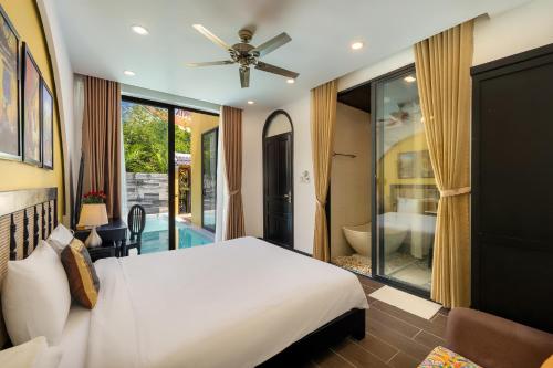 a bedroom with a white bed and a bathroom at Hoi An 2BR private Pool Villa - Walk to Old Town in Hoi An