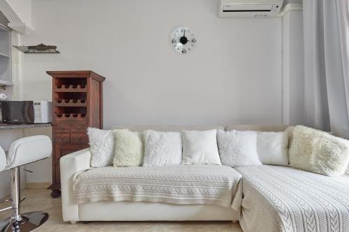 a white bedroom with a white couch with pillows at Lenas Apartments Pedro Lorca in Torrevieja