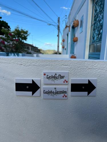 a sign on the side of a building with arrows at CASINHA FLOR, vila florescer, centro histórico! in Piranhas