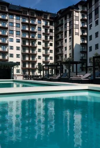 an empty swimming pool in front of some apartment buildings at Apartman Lux Titova Vila Plus Sony PS in Zlatibor