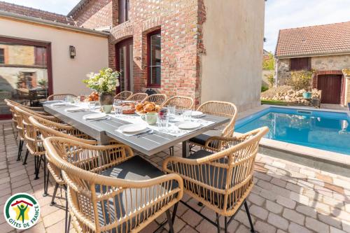 - une table et des chaises sur une terrasse avec piscine dans l'établissement Prelude Hautvillers, à Hautvillers