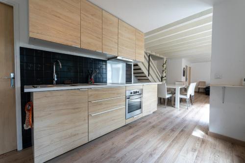 une cuisine avec des placards en bois et une salle à manger dans l'établissement L'Ecrin Vert - Maison 6 Chambres 12 Pers à Bdx, à Gradignan