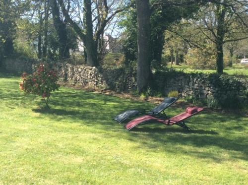 a park bench sitting in the grass in a field at Terre d'ajoncs in Saint-Philibert