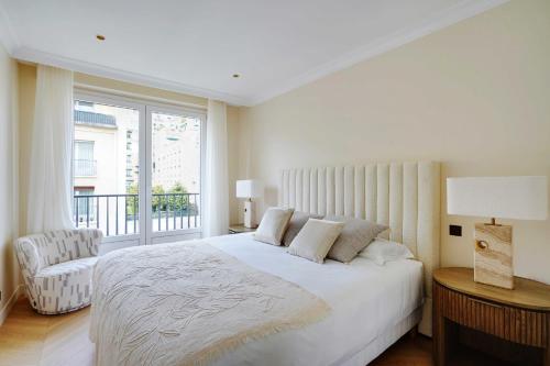 une chambre blanche avec un lit et une fenêtre dans l'établissement Luxurious apartment - 2BR- 6P Eiffel Tower view, à Paris