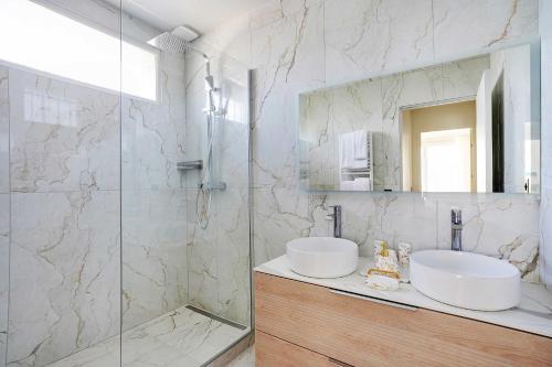 une salle de bain blanche avec un lavabo et une douche dans l'établissement Luxurious apartment - 2BR- 6P Eiffel Tower view, à Paris