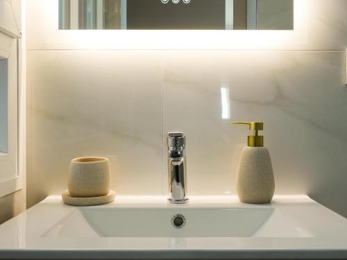 ein Waschbecken mit Wasserhahn und zwei Handtüchern in der Unterkunft Apartamento 3 habitaciones y 3 baños Playa de Gandía in Playa de Gandia