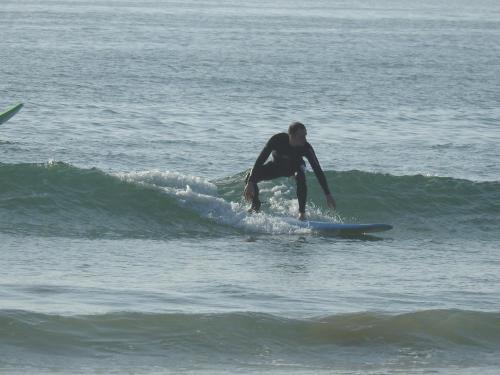 ein Mann, der auf einem Surfbrett im Meer auf einer Welle reitet in der Unterkunft A5 Bel Appartement vue mer a 300m de la plage in Agadir