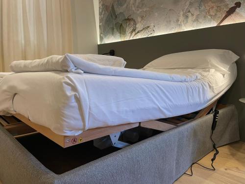 a bed with white sheets and pillows on top of it at Residence Mirabel in Tignale