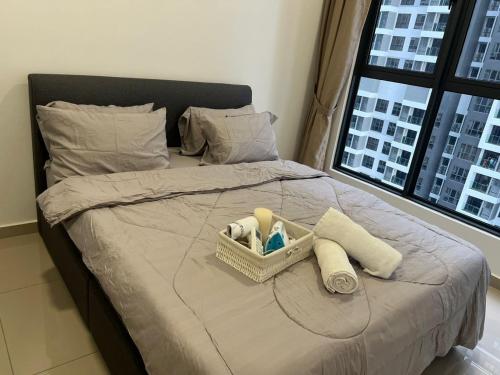 a bed with a basket of towels and a window at Shelisa's Modern 3BR House at Suria Garden Puchong in Puchong