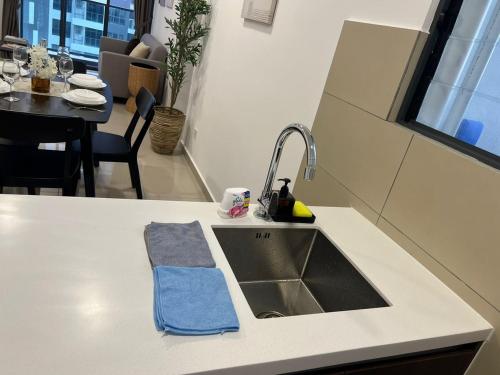 a kitchen counter with a sink and a table at Shelisa's Modern 3BR House at Suria Garden Puchong in Puchong
