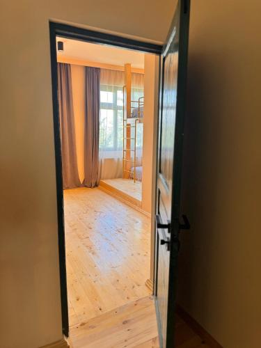 an open door to a room with a wooden floor at Our Old House in Tʼelavi
